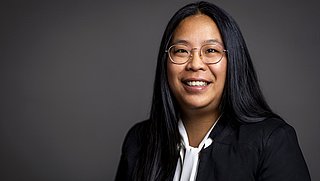 Porträt von Lucy Sun vor einem neutralen Hintergrund.