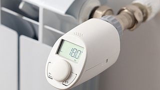 Weißer Heizkörper mit elektronischem Thermostat zur smarten Temperaturregelung und Energieeinsparung.