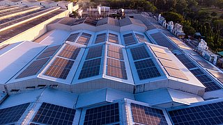Ein Gebäude mit vielen PV-Modulen auf dem Dach.