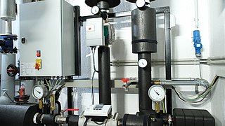 Die verkabelte Heizanlage im Keller. Rohre, Pumpen und Anlegefühler.
