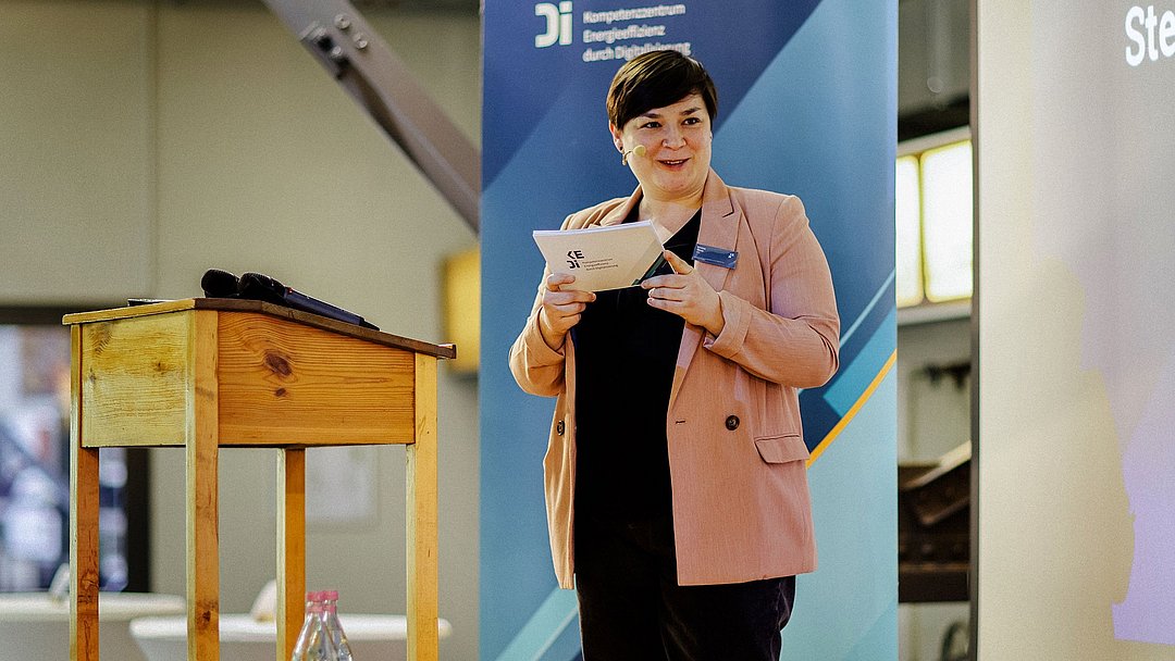 Elvira Hinz steht auf der Bühne und moderiert die Veranstaltung.