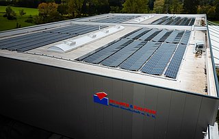 Außenansicht auf die Werkhalle der Kanter & Schlosser. Auf dem Dach ist eine neue PV-Anlage.