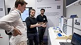Detailansicht auf e2d2 – der KMU-Demonstrator: Drei Menschen stehen am Modell und unterhalten sich.