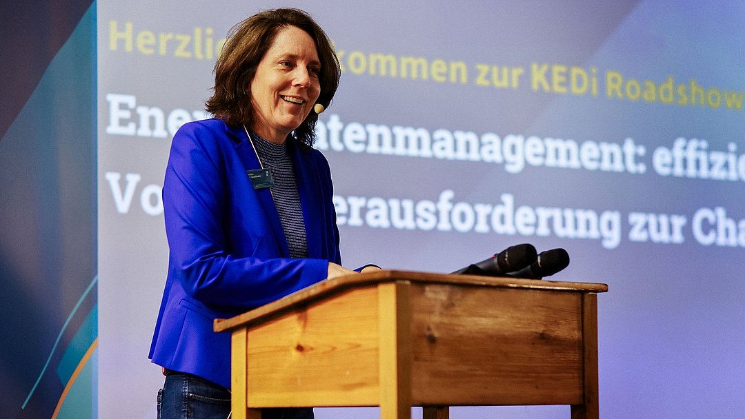 Dr. Andrea Gauselmann steht an einem Pult auf der Bühne und hält ihren Vortrag.