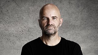 Porträt von Holger Kühl vor neutralem Hintergrund.