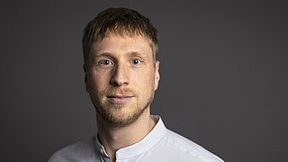 Porträt von Dr. Lars Sorge vor einem neutralen Hintergrund.