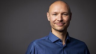 Porträt von Maximilian Liebich vor einem neutralen Hintergrund.