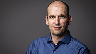 Porträt von Martin Meilick vor einem neutralen Hintergrund.