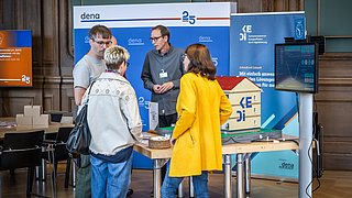 Vier Personen stehen um das Gebäude-Modell DEEP herum und unterhalten sich.