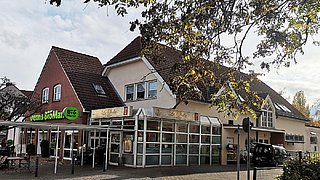Auf dem Bild ist das Gebäude mit Gewerbefläche und Wohnungen zu sehne.